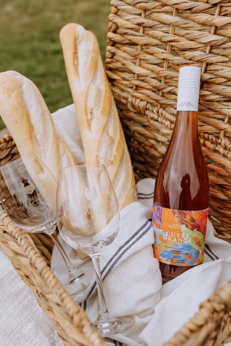 Baguettes de pain et bouteille de vin dans un panier en osier pour pique-nique