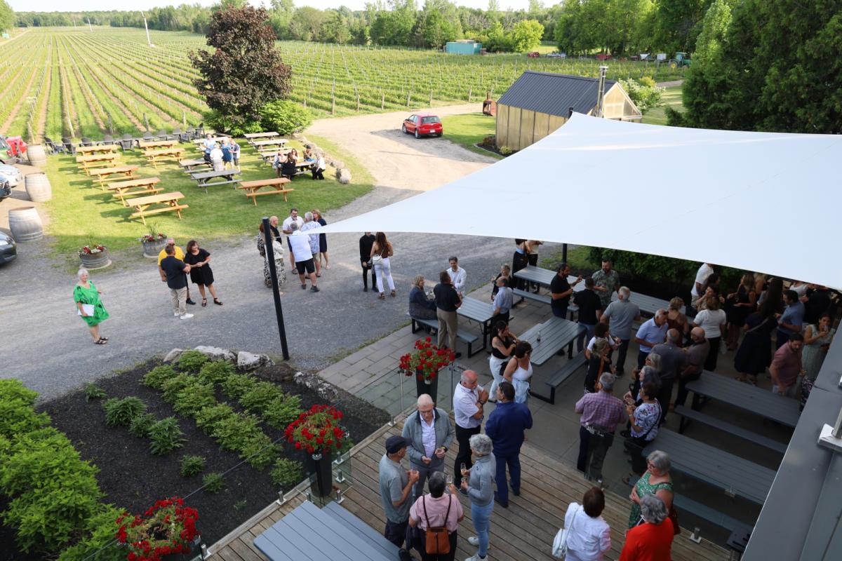 Personnes discutant sur une terrasse et buvant un verre de vin