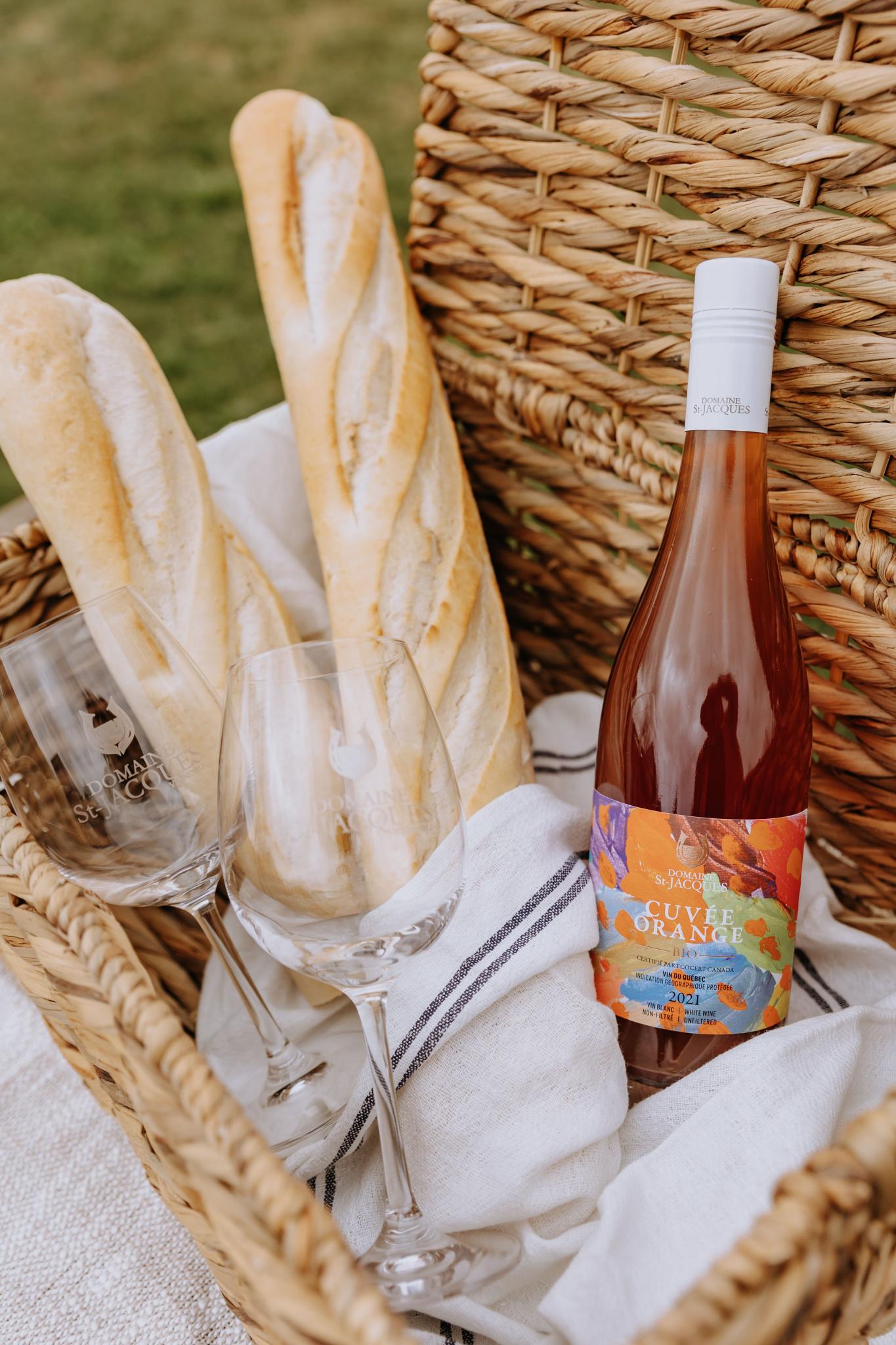 Baguettes de pain et bouteille de vin dans un panier en osier pour pique-nique